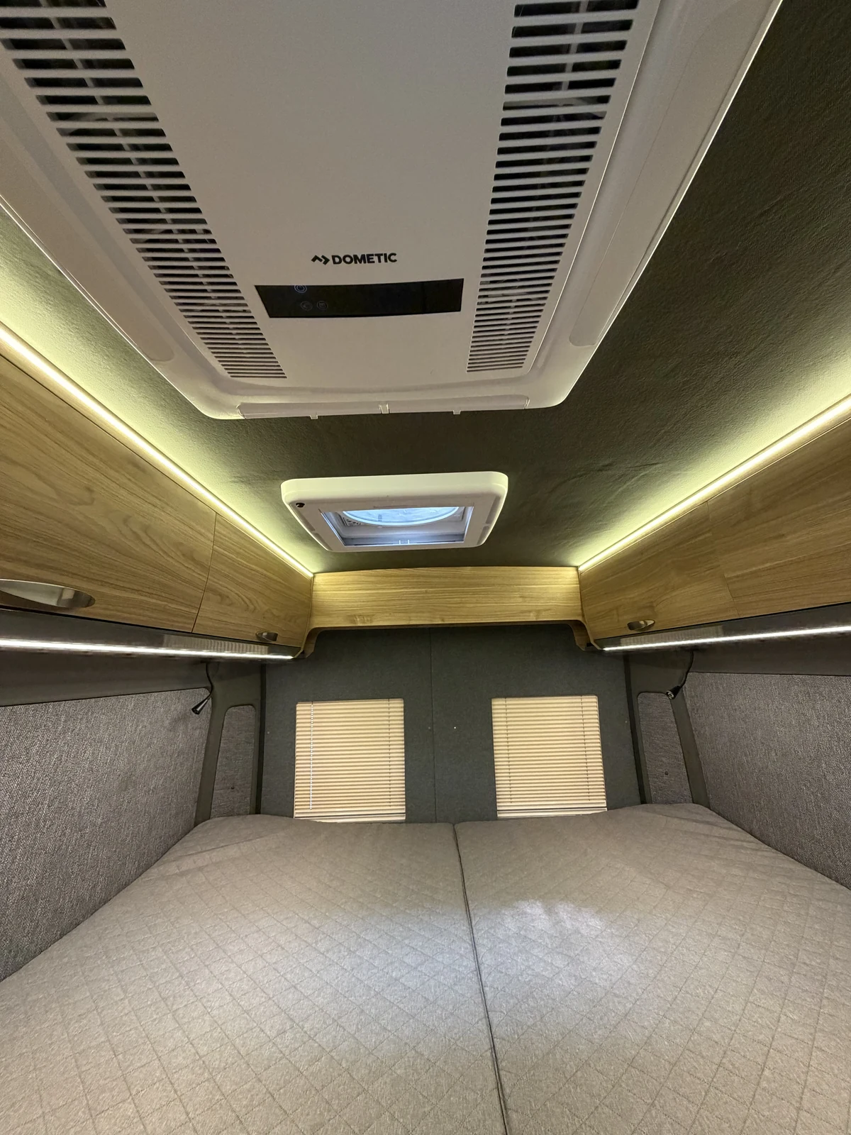 BeBrightCamp sleeping area with wood overhead cabinets, integrated lighting and ceiling air conditioning