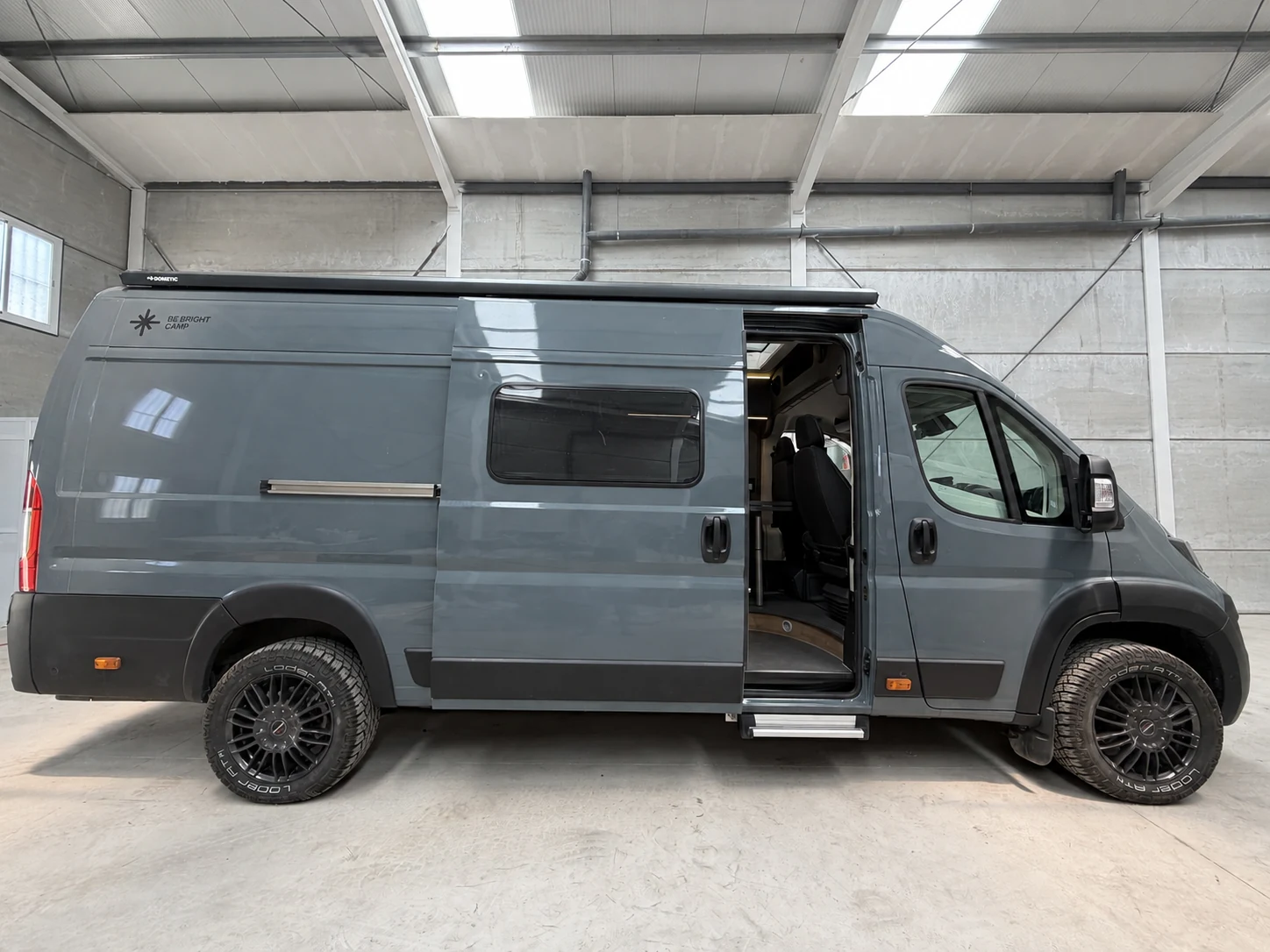 BeBrightCamp campervan with its sliding door open in the workshop